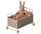 Maileg Toy rabbit in a small cot with floral pattern on a white background
