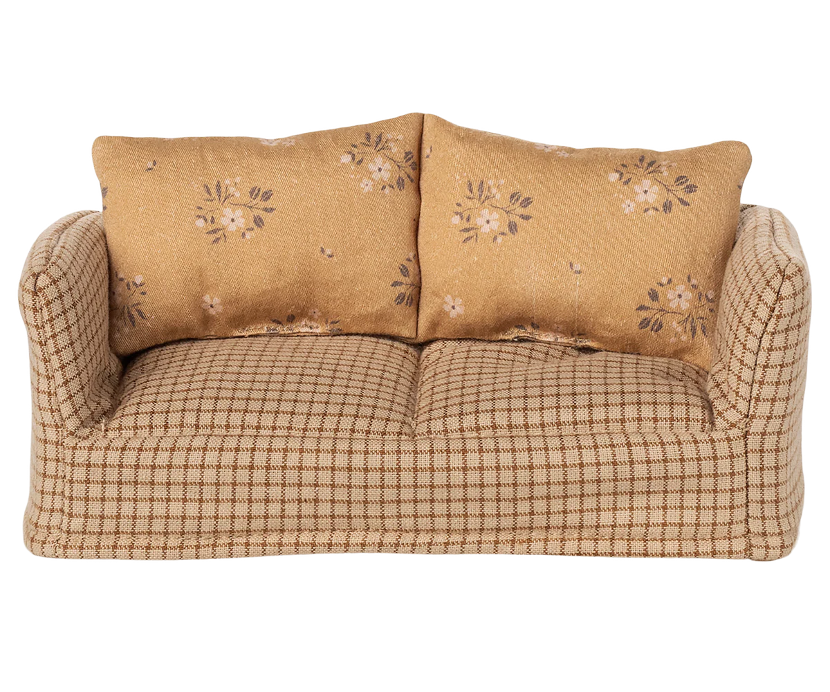 Beige sofa with floral-patterned cushions on a white background
