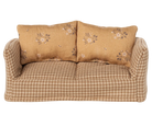 Beige sofa with floral-patterned cushions on a white background