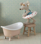 Miniature bathroom set with toilet, sink, bathtub, and decorative elements on a patterned wall background.