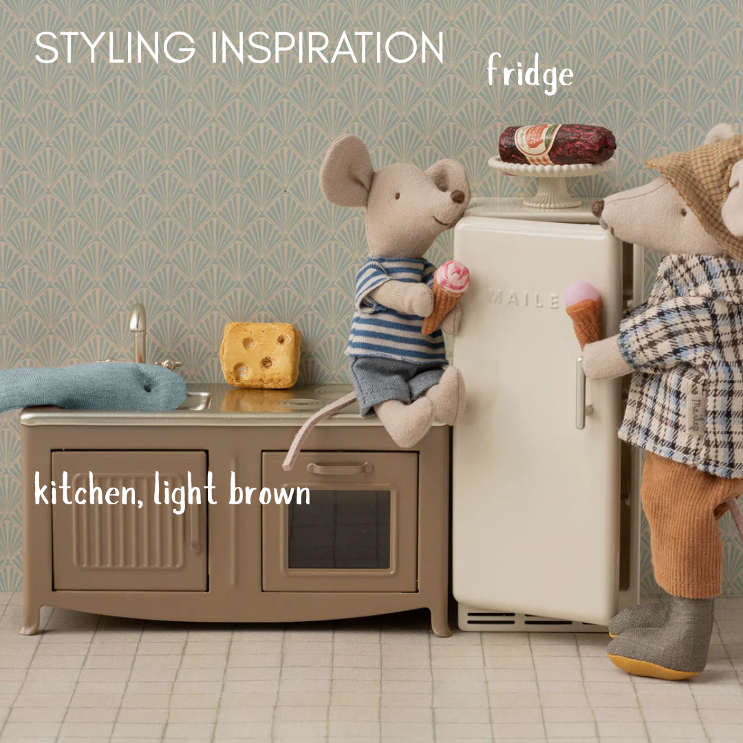 Children's dolls house kitchen set with toy mice and refrigerator, styled as a kitchen.