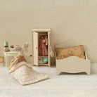 Maileg Miniature bedroom set with bed, chair, a princess mouse and wardrobe against a patterned wall.