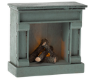 A miniature Maileg wooden fireplace with a vintage blue finish, featuring faux logs inside.