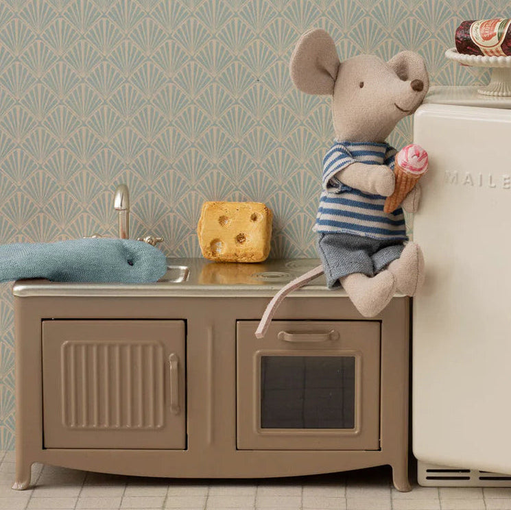 Two toy mice in a kitchen setting with a refrigerator and sink.