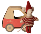 A Maileg mouse doll wearing a red and beige striped knit sweater and red hat, posed next to a red and brown cardboard toy car with the Maileg logo on the side, on a white background.