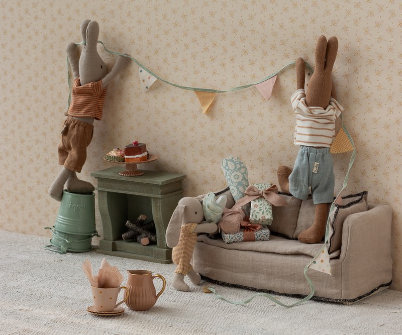 Maileg rabbits in a living room hanging up bunting