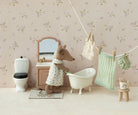 Miniature bathroom scene with a maileg mouse character in a bathrobe, bathtub, and floral wallpaper.