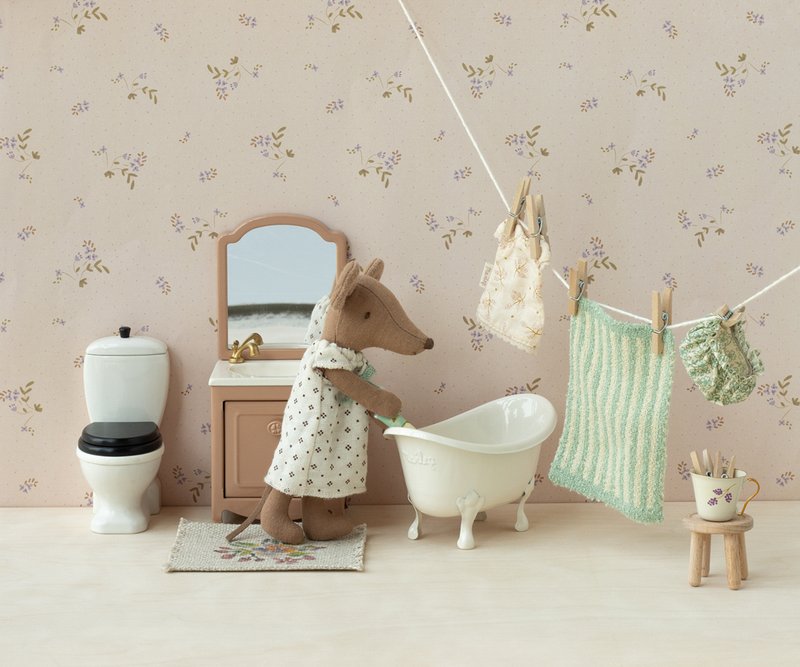 Miniature bathroom scene with a maileg mouse character in a bathrobe, bathtub, and floral wallpaper.