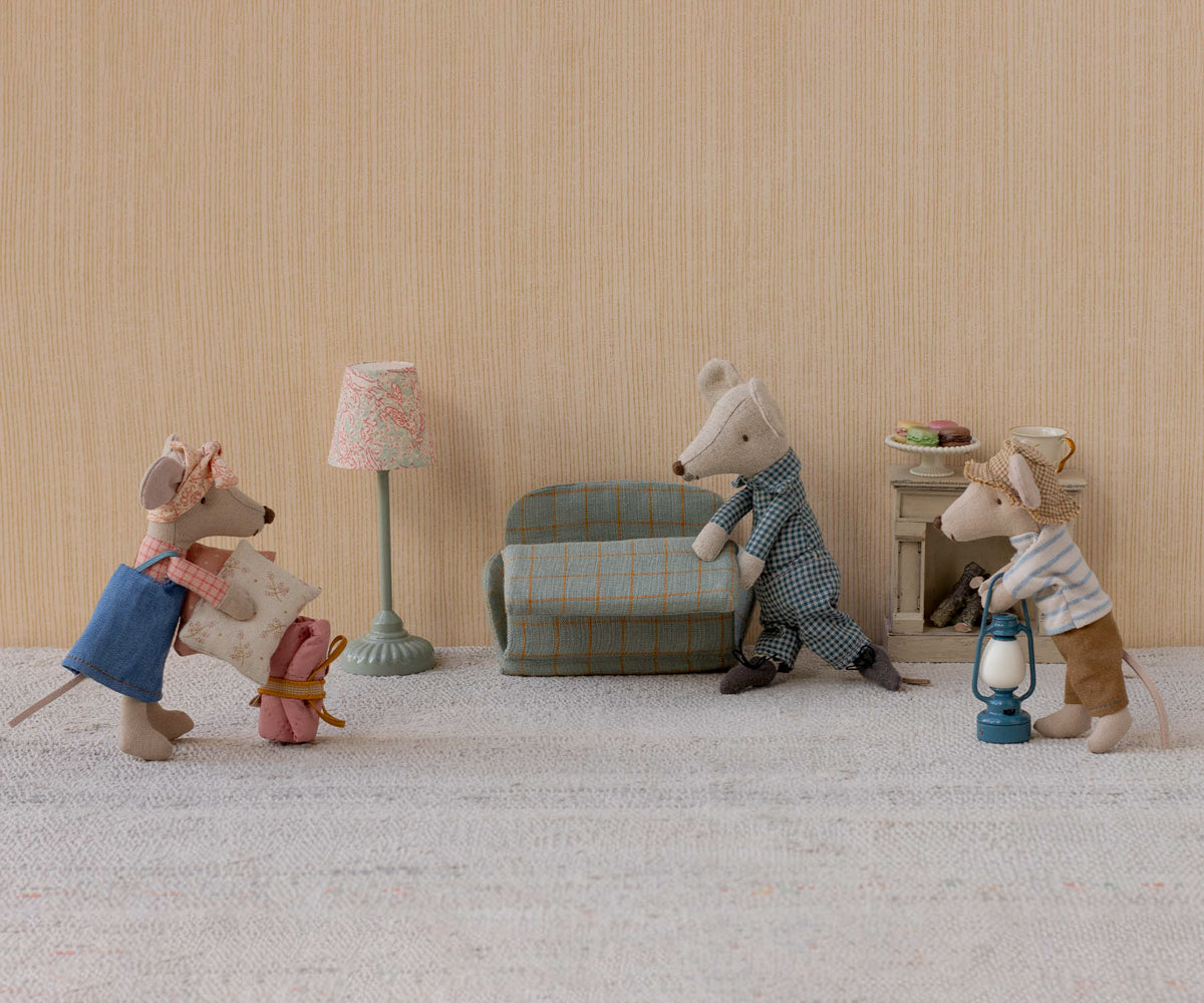 Miniature scene with toy mice in a living room setting.