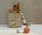 Children's room with a beige dresser, toys, and a pumpkin toy on a light gray floor.