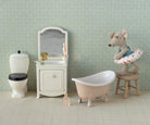 Maileg toy Miniature bathroom set with bathtub, toilet, and vanity against a patterned wall.