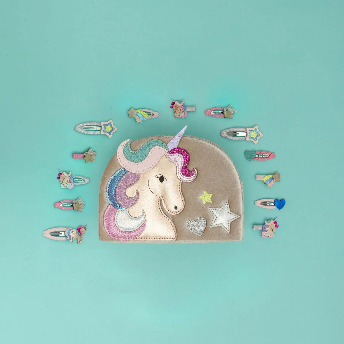 A pastel unicorn-themed coin purse with embroidered patches, surrounded by matching small accessory pieces on a solid aqua background.