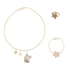 Jewelry set with gold unicorn necklace, ring, and bracelet on a white background