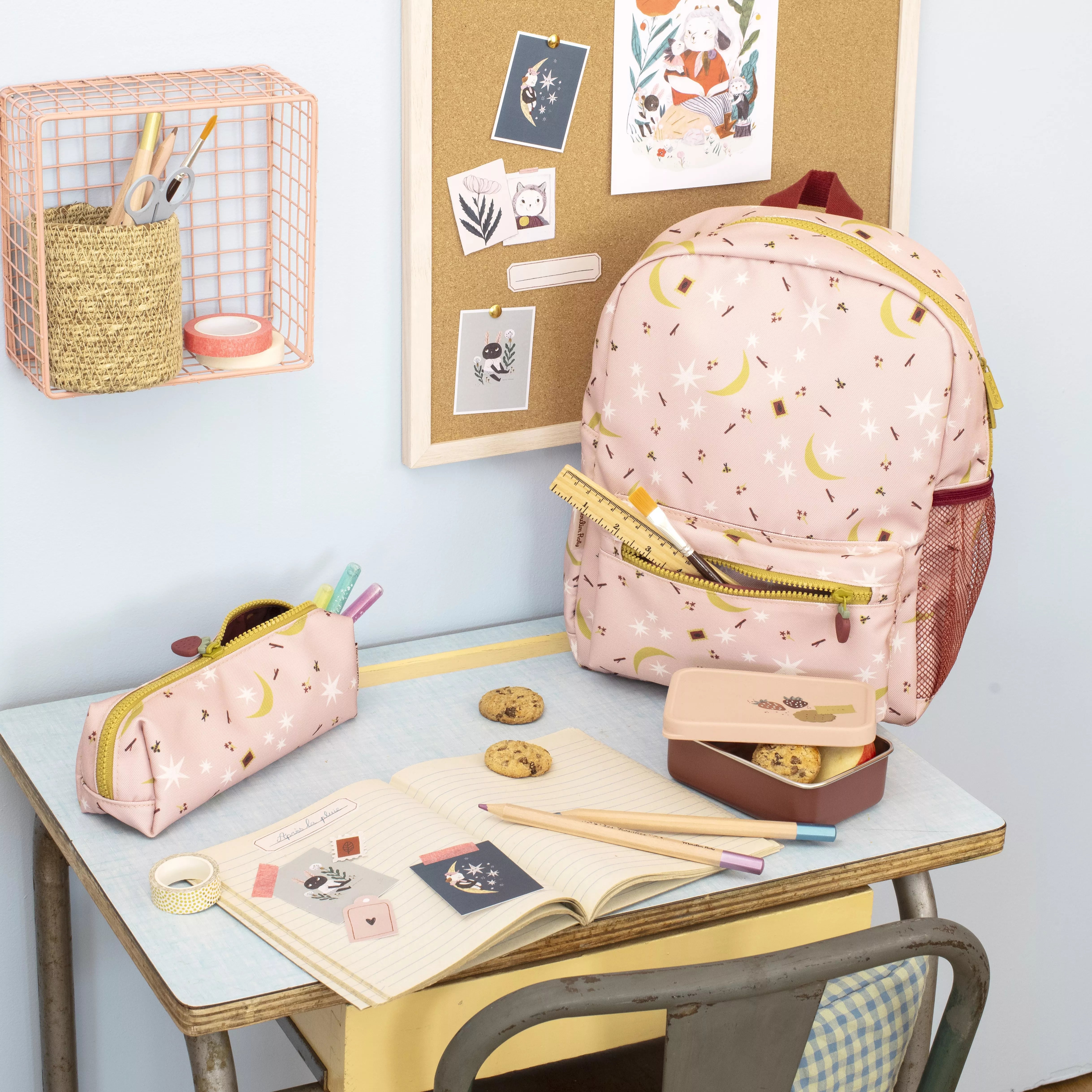 Moulin roty Pink backpack and pencil case on a school desk with stationery items
