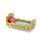 Yellow doll bed with floral design and pink pillow on a white background