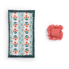 Floral-patterned pillow and red striped bowl on a white background