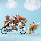 Toy bears on a bicycle with a blue sky background