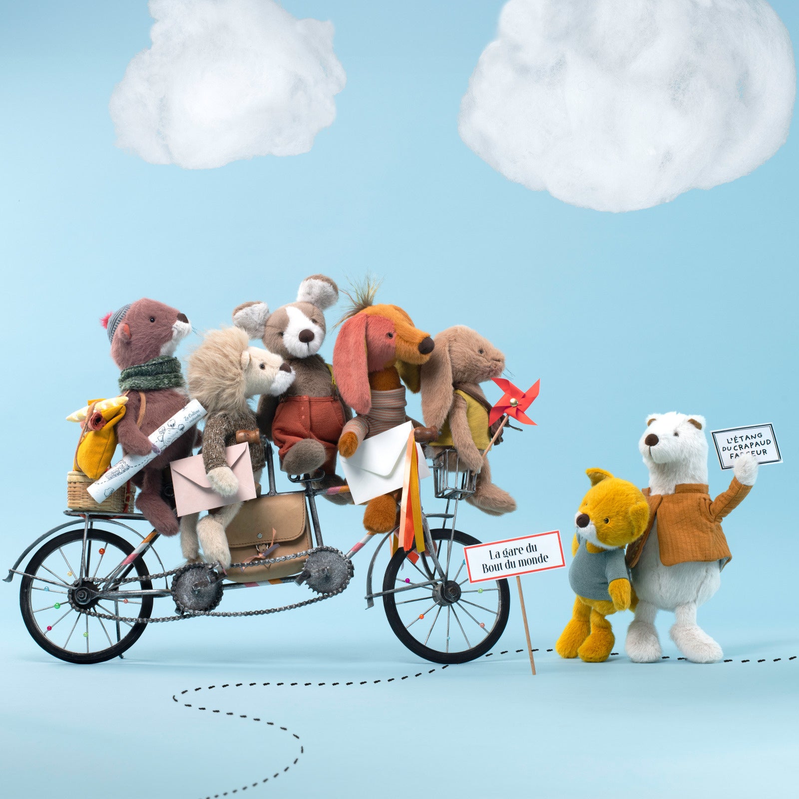 Toy bears on a bicycle with a blue sky background