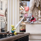 Plush toys on a balcony with a classical statue in the background