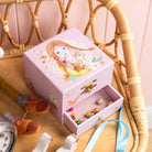 Pink jewelry box with a girl design on a wooden chair