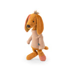 A plush toy dog wearing a beige and pink striped turtleneck sweater, standing against a solid white background.
