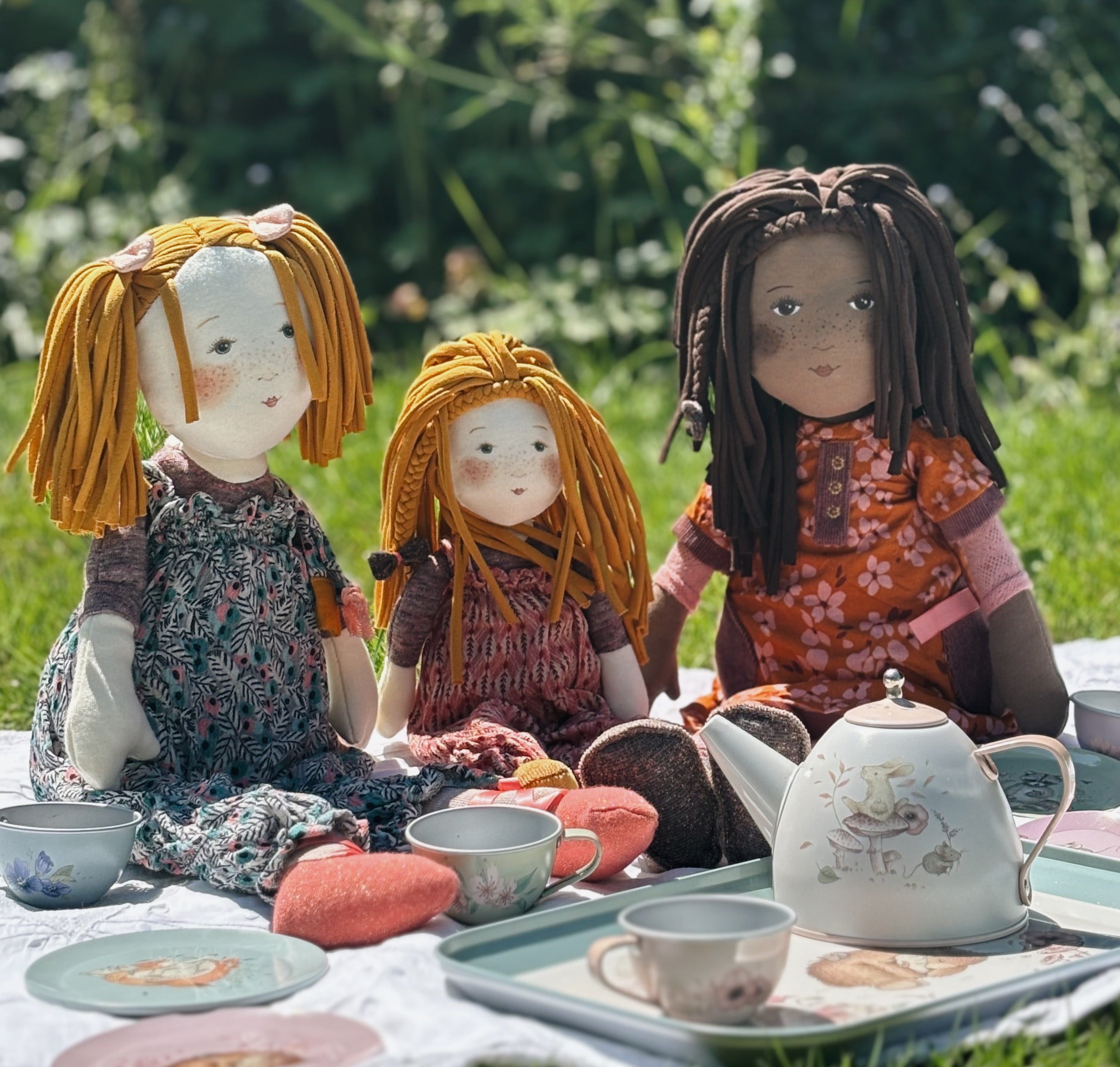 Moulin Roty Rosalies rag dolls sitting in a garden having a tea party