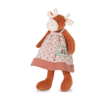 Plush toy cow wearing a floral dress on a white background