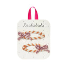 Two candy cane-shaped hair clips with pink bows on a Rockahula branded card.