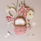 Collection of hair accessories including bows and a small bag on a beige background