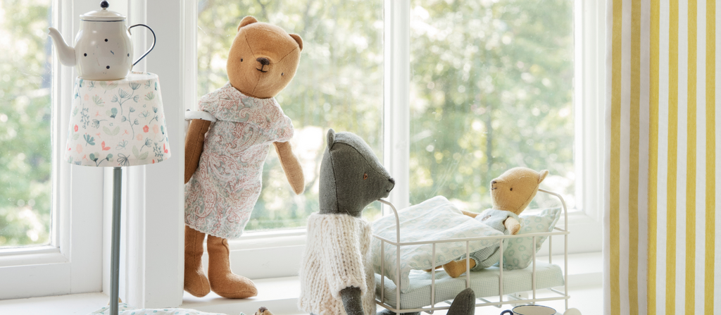 Maileg teddies in a cot with floor lamp