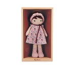 Doll in a pink floral dress and bonnet in a wooden box with 'Kaloo' branding.