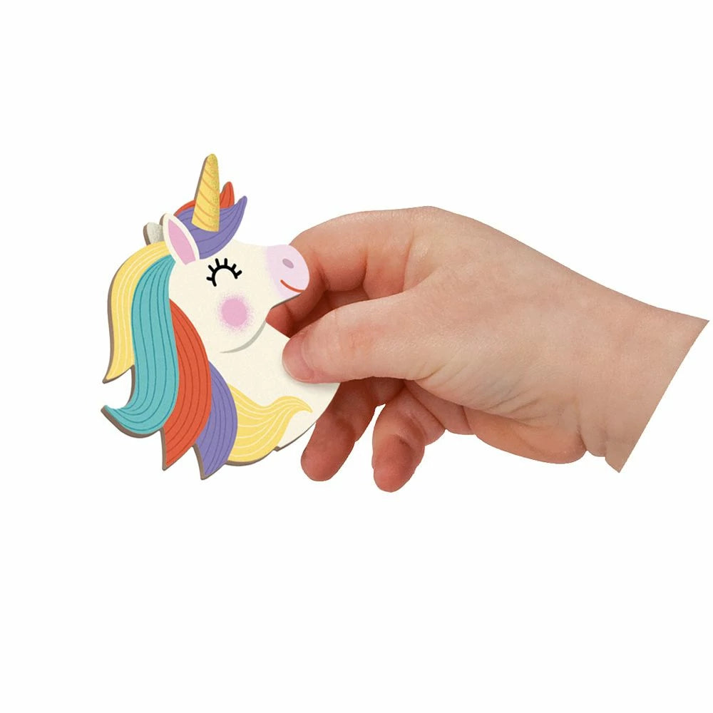 Hand holding a colorful unicorn-shaped object against a white background