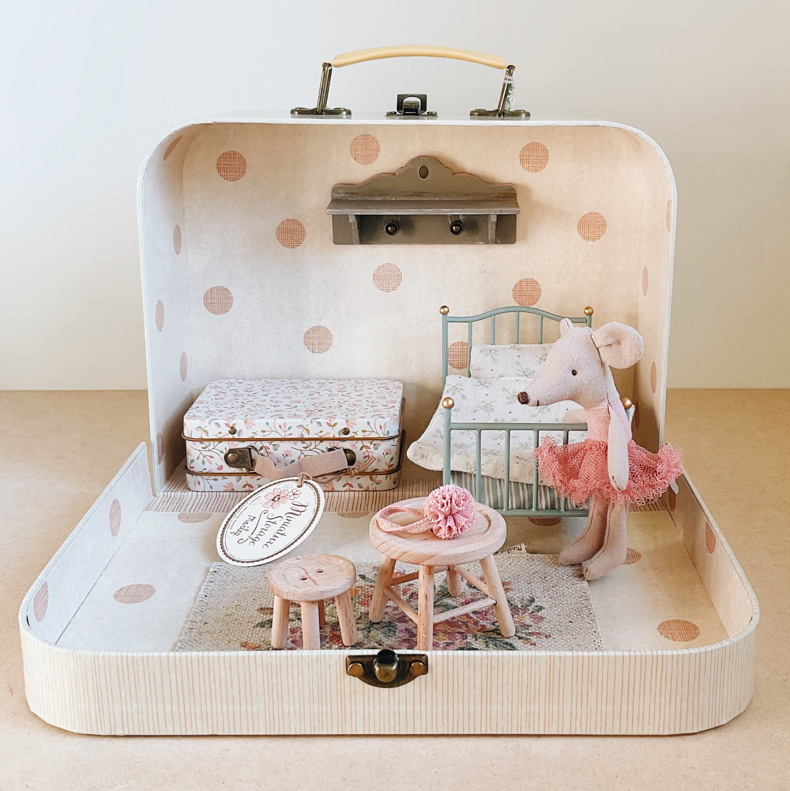 Miniature dollhouse scene inside a polka dot suitcase with a toy mouse in a tutu.