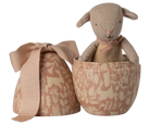 Stuffed animal toy in a patterned box with a matching bow on a white background