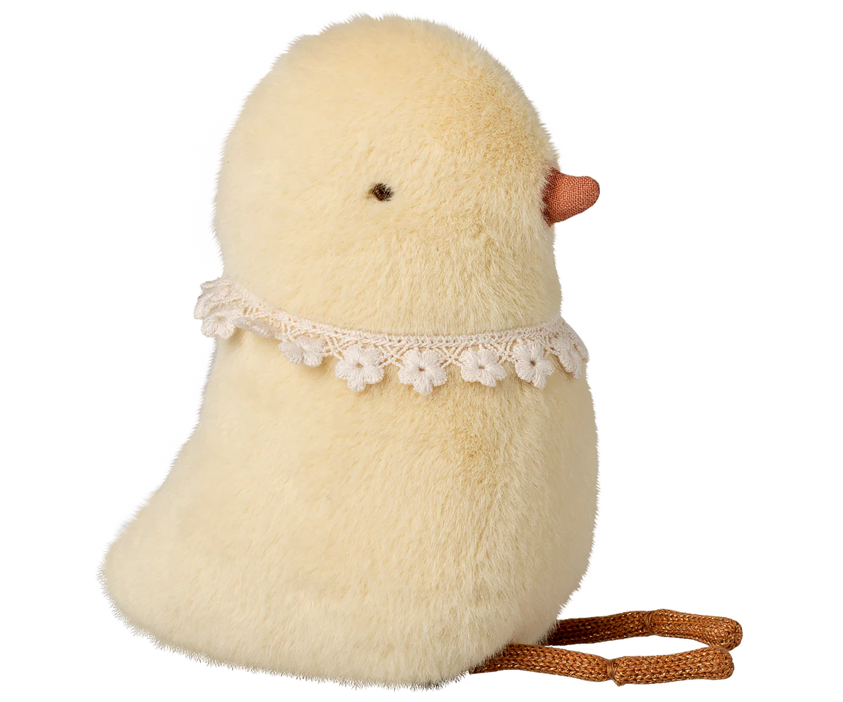 Stuffed toy chick with a lace collar and brown rope on a white background