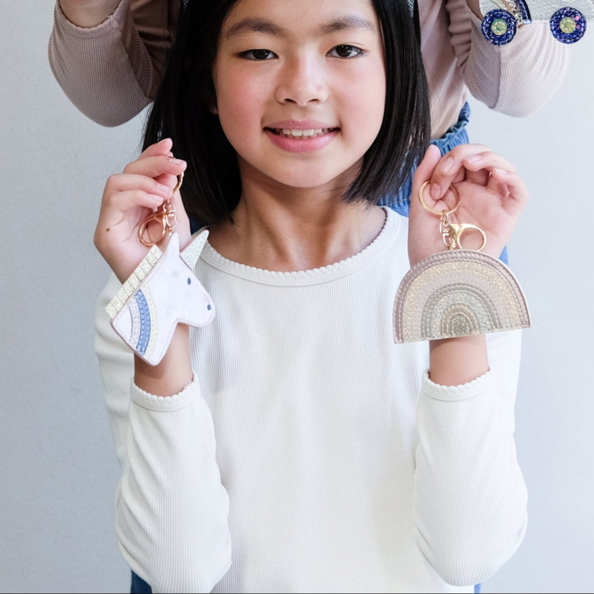 girl holding unicorn key ring 