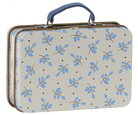 A miniature metal suitcase with a blue floral pattern on a beige background.